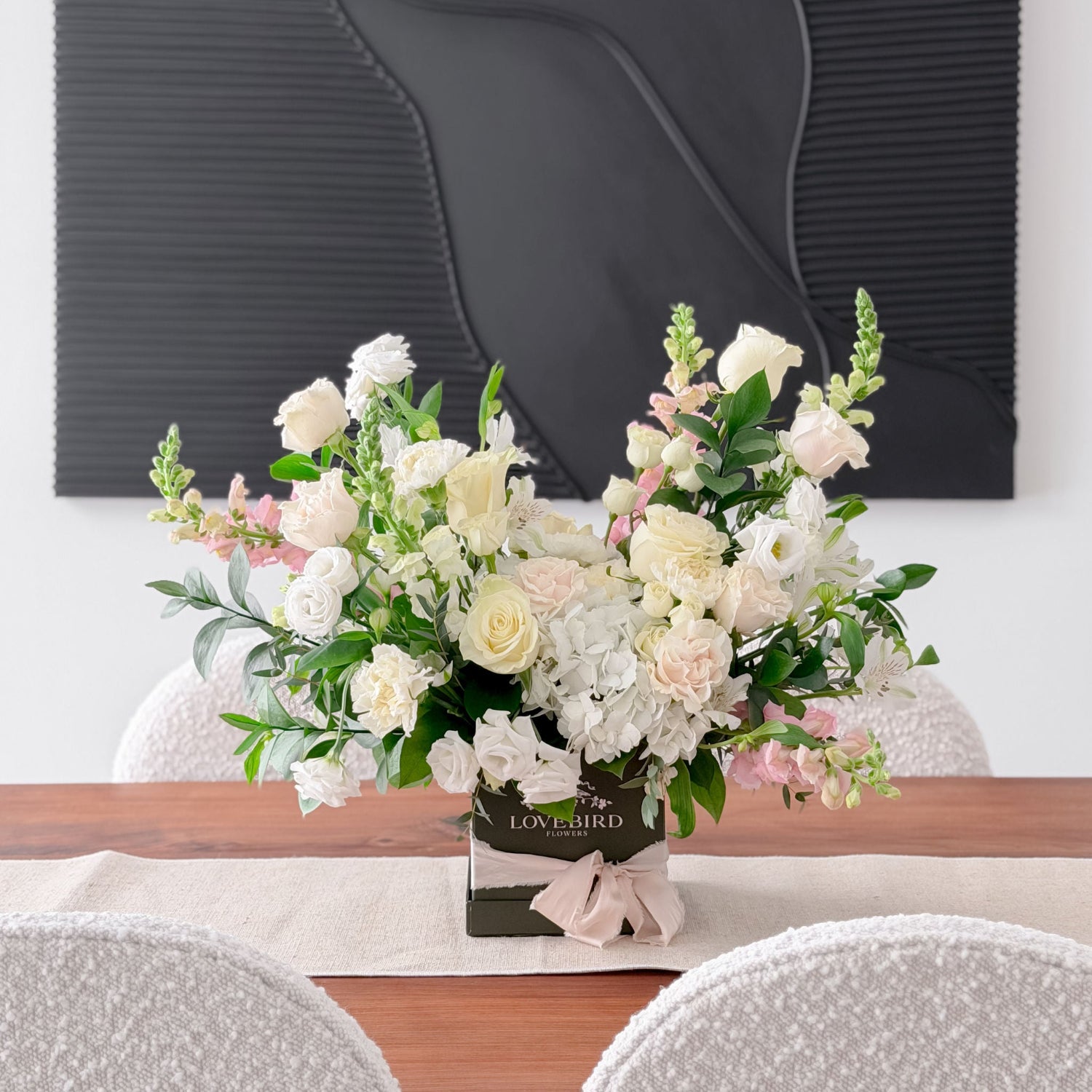 Always & Forever Valentine's arrangement featuring white roses, hydrangeas, and blush pink blooms in a Lovebird Flowers hatbox in London, Ontario on a modern dining table