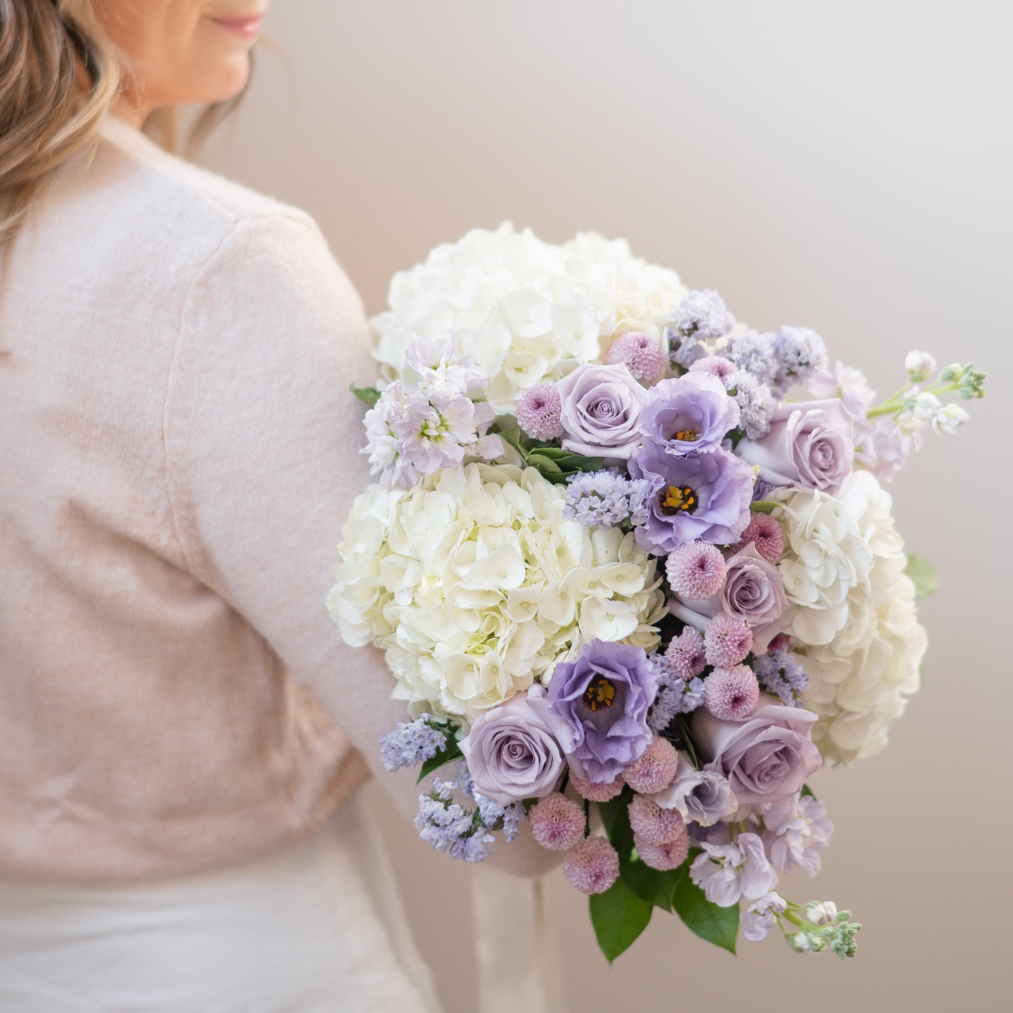 white hydrangea and lavender rose and lisianthus bouquet with lavender stock and statice.