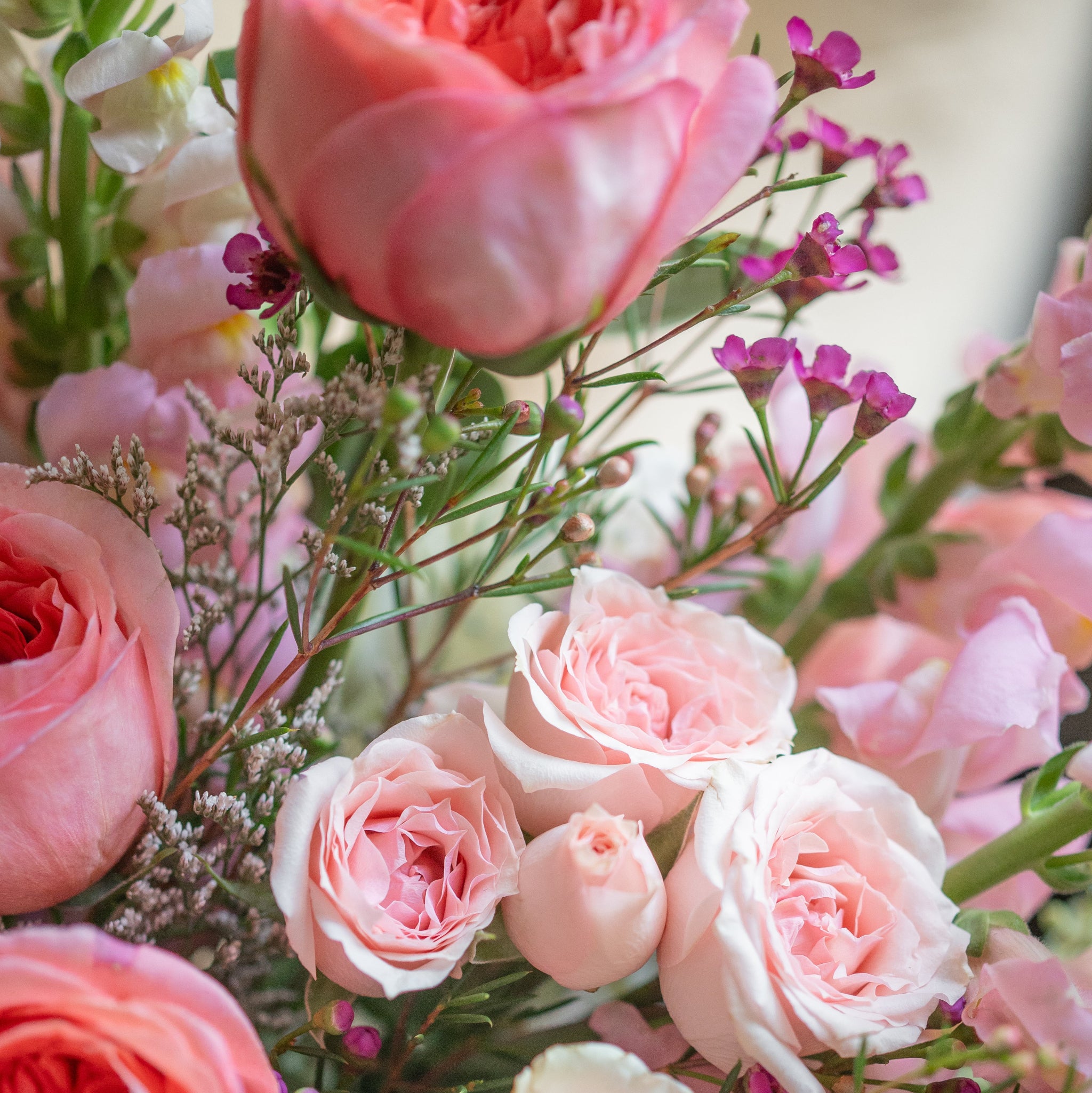 Bouquet of pink and peach roses with greenery