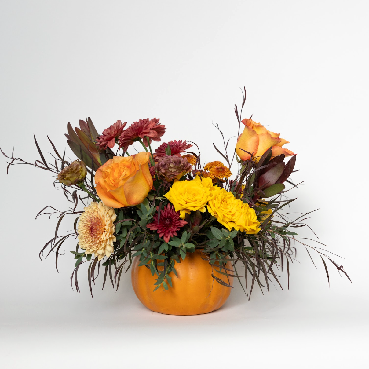 fall textural floral arrangement in a ceramic pumpkin