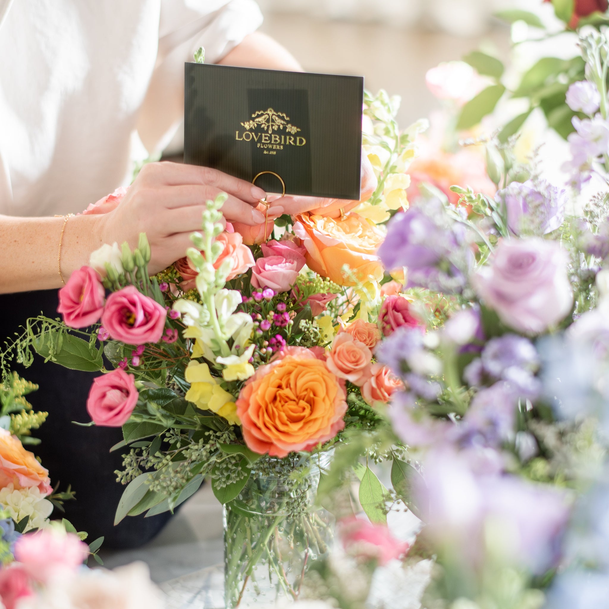 lovebirdflowers note card going in a bright sunset toned floral arrangement with free spirit roses and pink lisianthus
